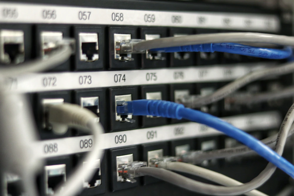Sala de servidores com racks alinhados e cabeamento organizado