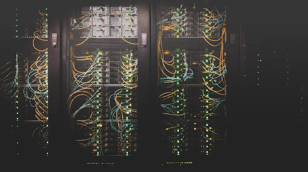 Corredor de um data center com fileiras de servidores iluminados em azul
